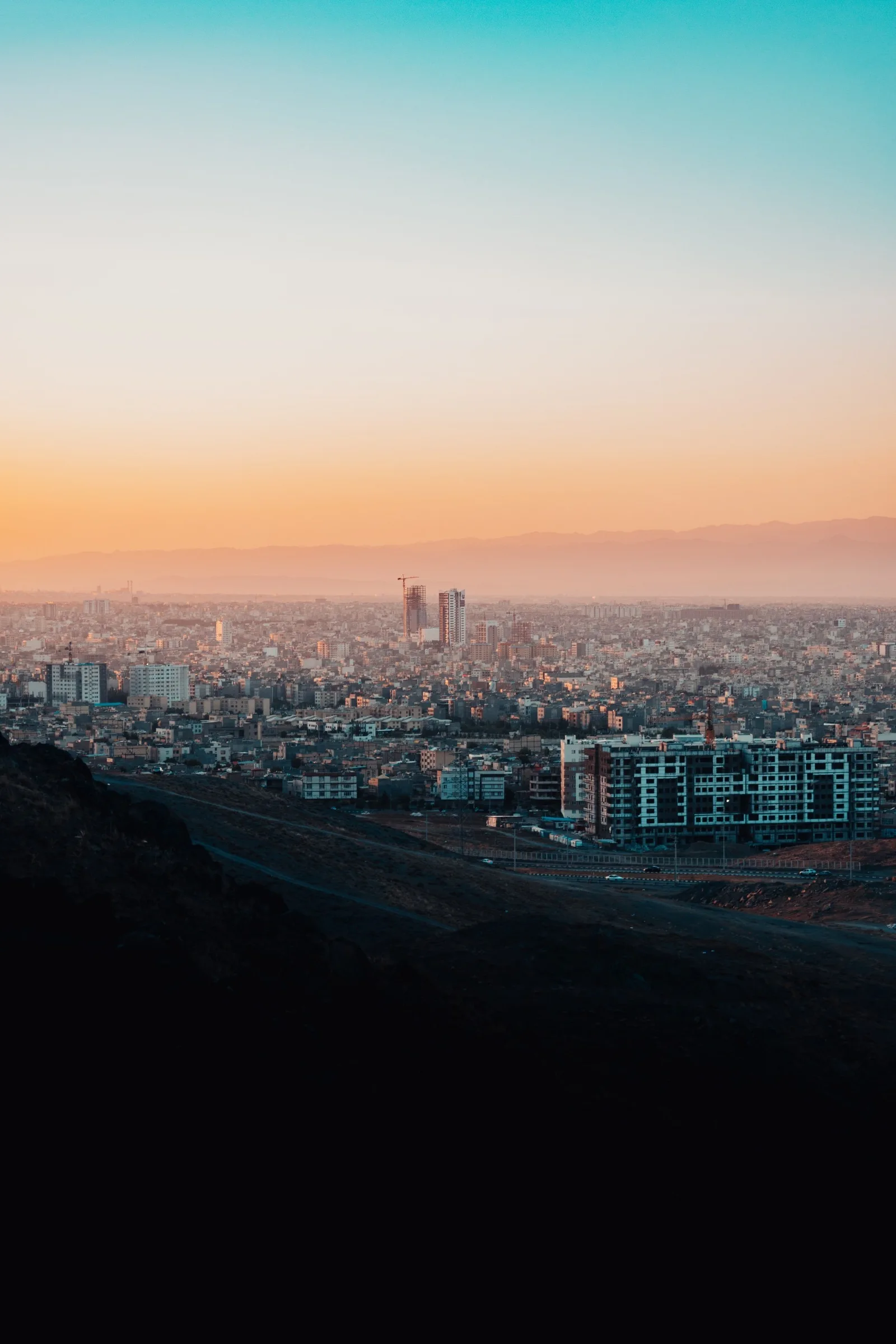 City skyline beneath a pastel sunset.