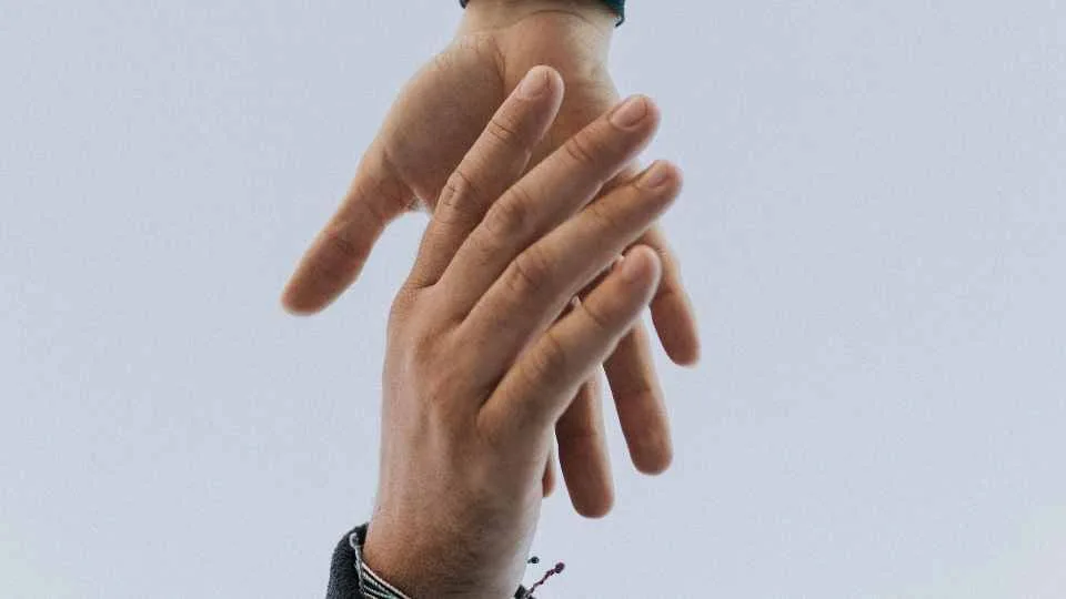 Two hands reaching toward one another.