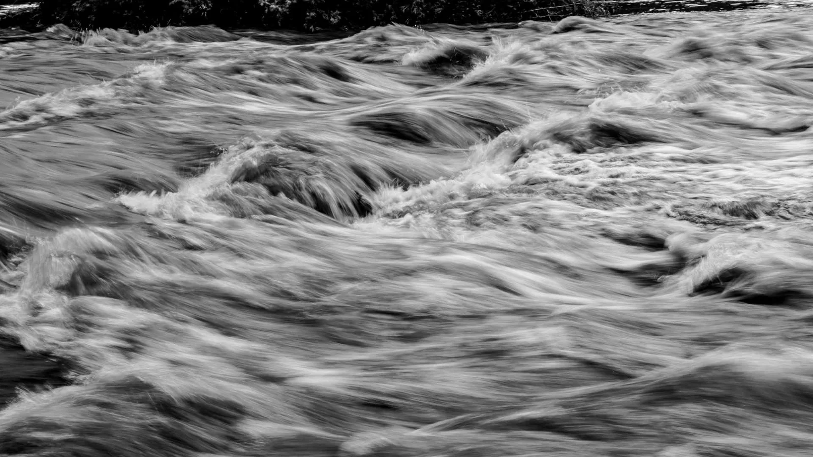 Black-and-white photograph of rushing water.