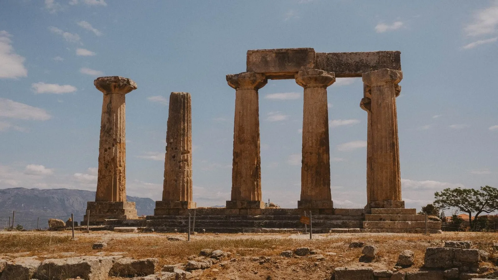 Ancient stone columns and ruins beneath a blue sky.