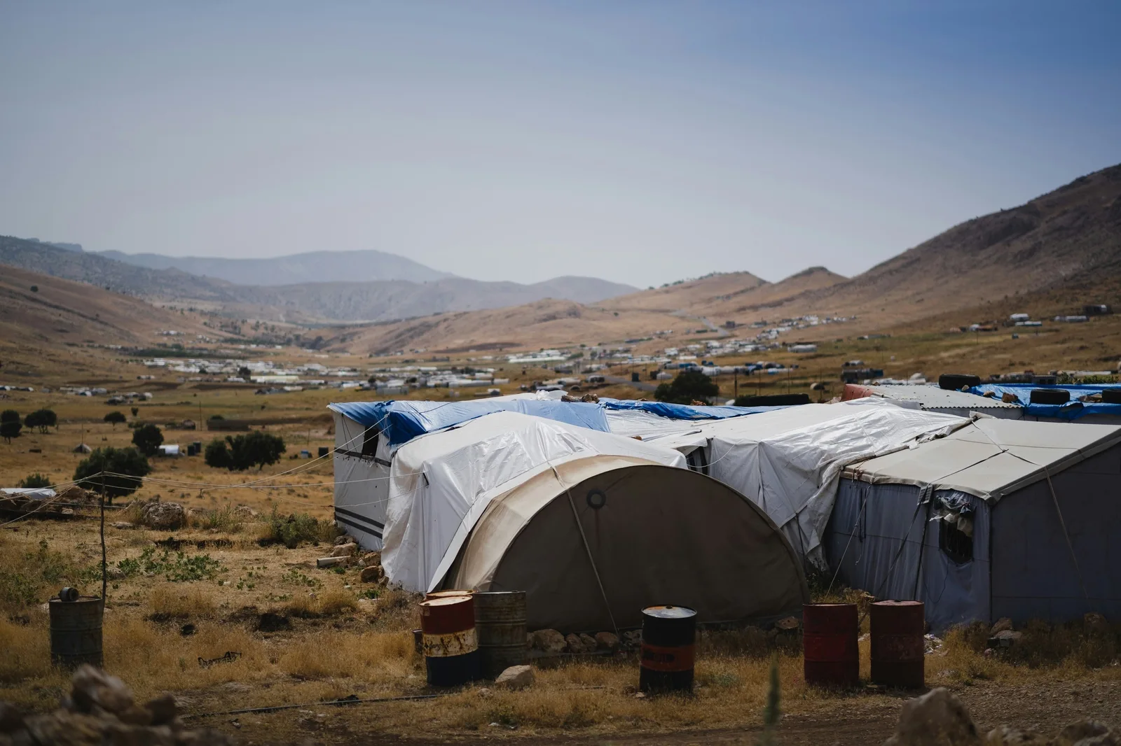 Tents and temporary shelters in a dry mountain valley.